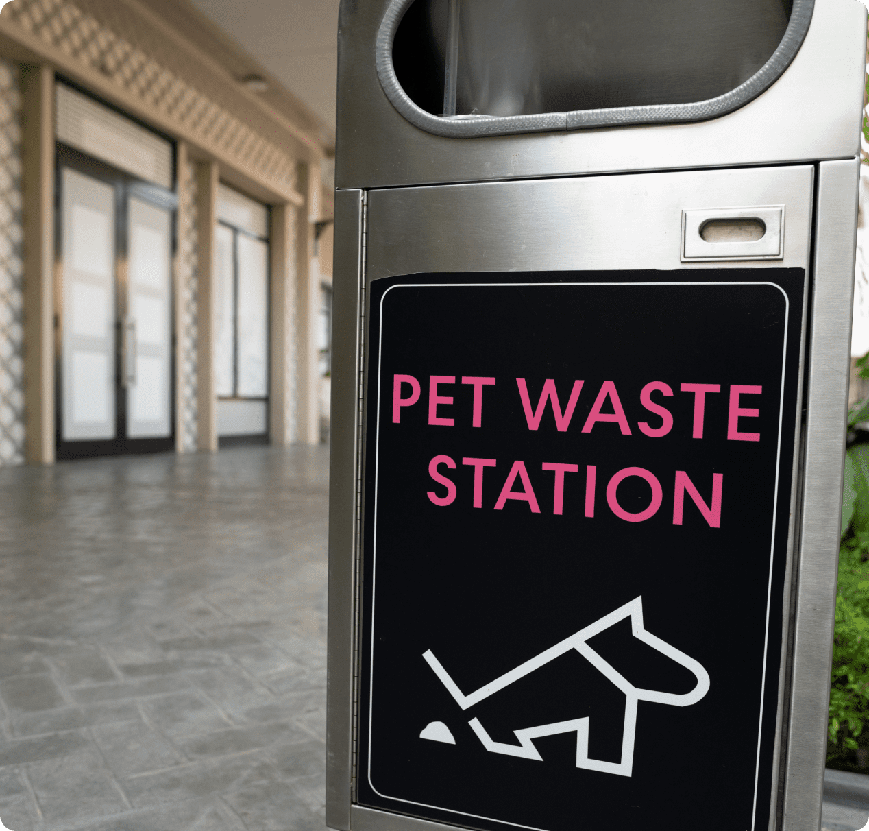 A sign that says pet waste station in front of a building.