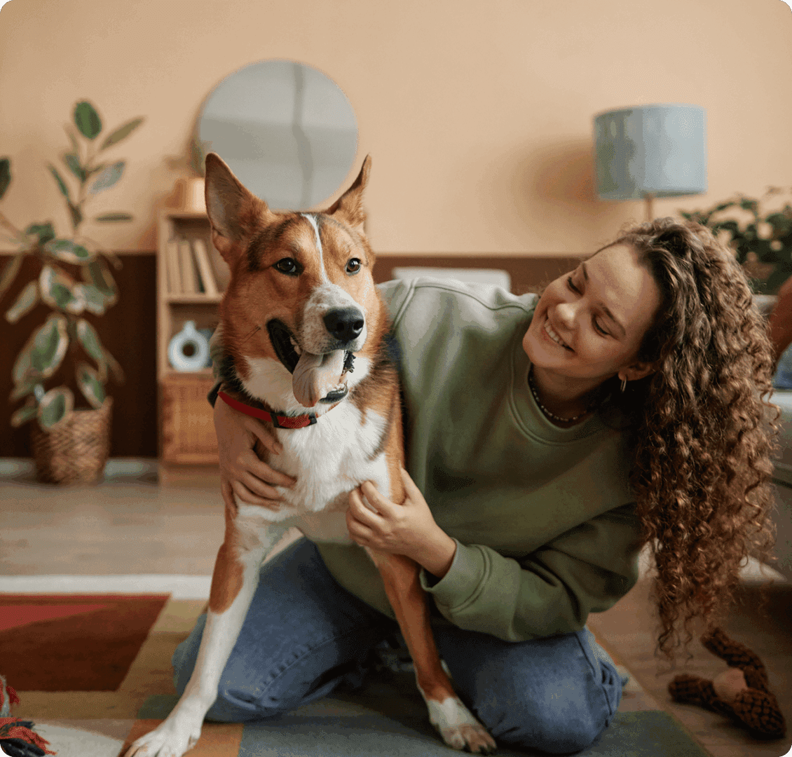 Woman smiling and hugging a happy dog.