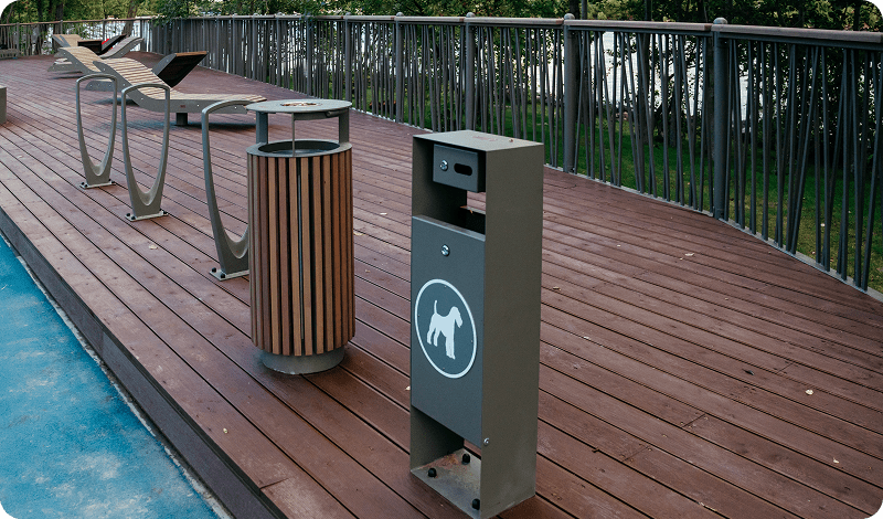 Dog waste station on wooden deck walkway.